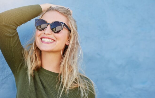 Smiling woman wearing sunglasses.