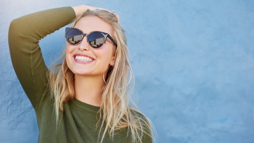Smiling woman wearing sunglasses.