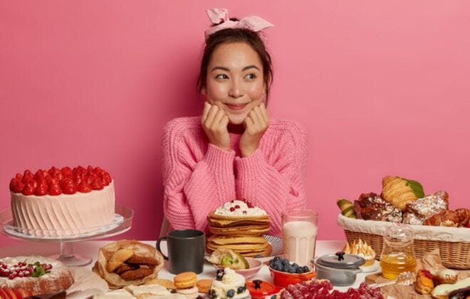Satisfied woman sitting in front of dessert table.