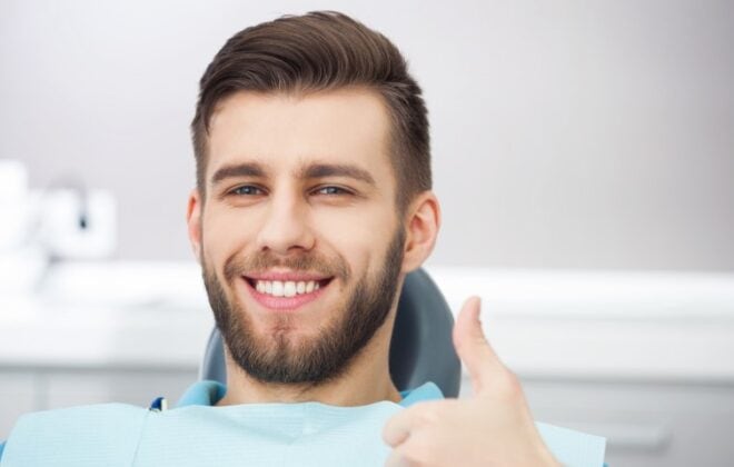Smile male patient in dental chair.